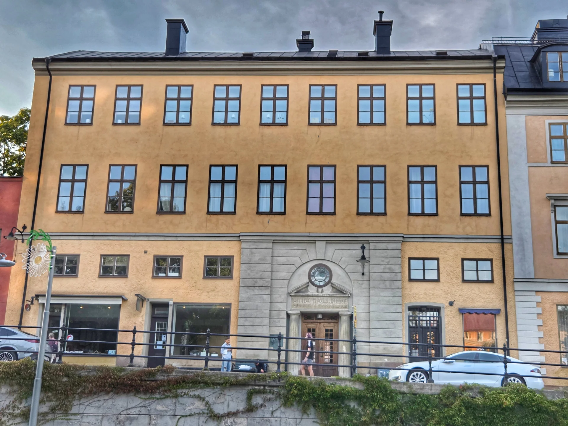 Gul flervåningsbyggnad med stenportal och fönsterrader, sedd under en stadsvandring Mariaberget
