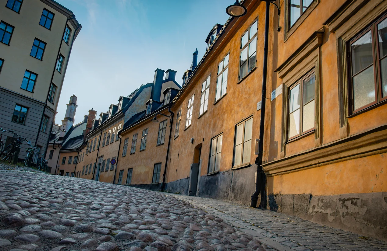 Kullerstensgata som slingrar sig uppåt mellan äldre husfasader i Mariaberget, perfekt för en stadsvandring