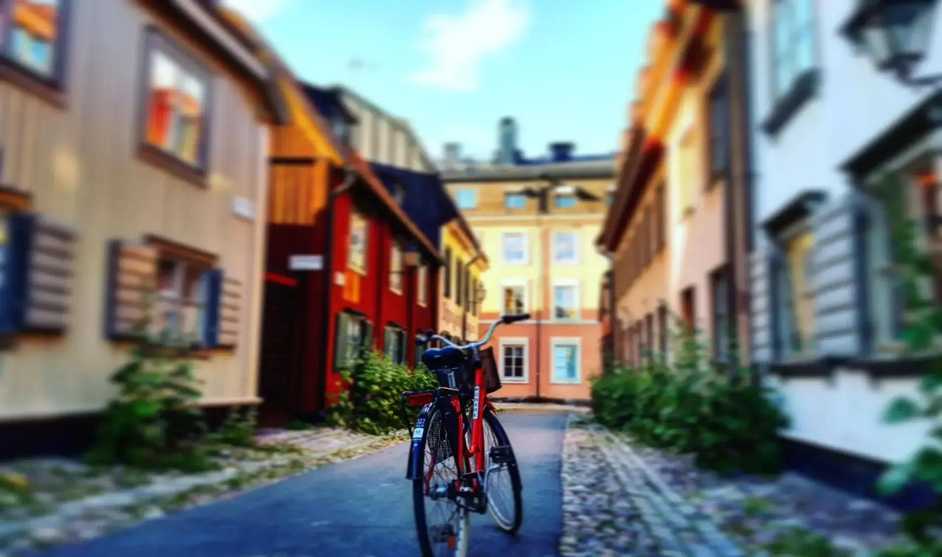 Röd cykel parkerad på gata med färgglada hus